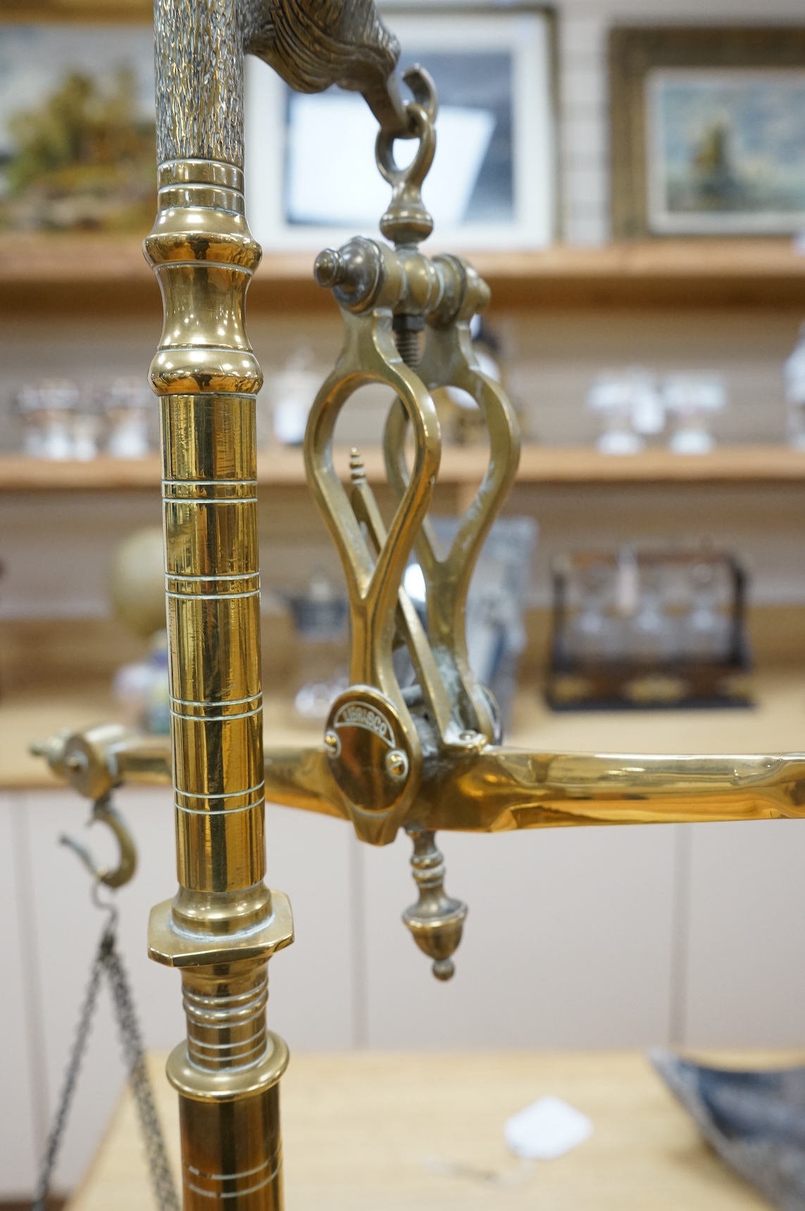 A pair of brass beam scales with decorative bull's head finial and weights, 56cm high
